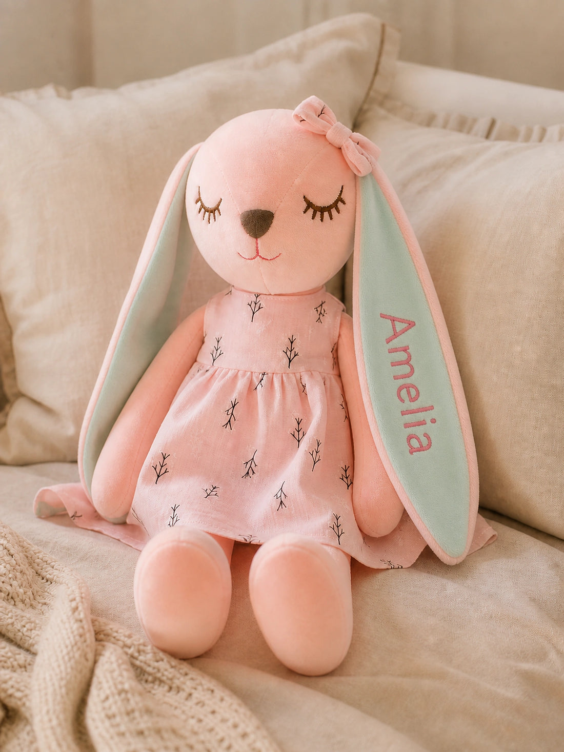 Lapin en peluche rose en robe rose à motif de branches avec Amelia brodé sur l’oreille vert menthe