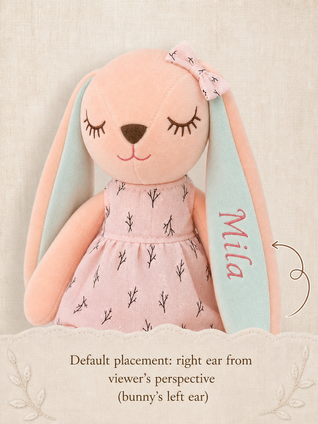 Gros plan sur Mila brodé sur l’oreille droite du point de vue de la personne qui regarde du lapin rose en robe rose