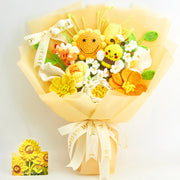 Ramo de ganchillo completo con envoltorio amarillo, girasol sonriente, pequeña abeja, flores amarillas, naranjas y blancas, hojas verdes, cinta y tarjeta