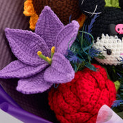 Macro view of purple crochet lily and red rose beside the KM doll and sunflower
