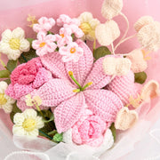 Close-up of pink crochet lily, rose, small blossoms, and cream heart accents