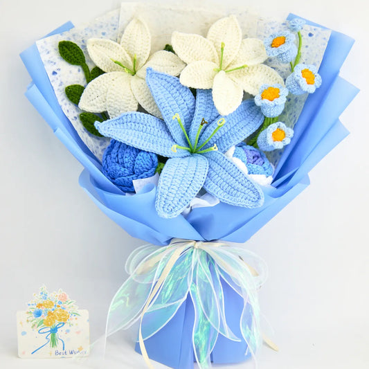 Bouquet au crochet emballé en bleu avec un lys bleu, deux lys blancs, deux roses bleues et du muguet bleu, noué d’un ruban irisé