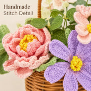 手編みの編み目と緑の葉が見える、重なりのあるピンクと紫のかぎ針編みの花の接写