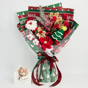 Vista frontale del bouquet natalizio rosso e verde all’uncinetto con Babbo Natale, figura di pan di zenzero, renna, albero e fiori rossi