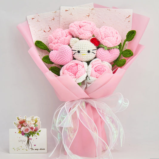 Vista frontale del bouquet rosa di rose all'uncinetto HK con cinque rose, due cuori, motivo HK bianco, foglie verdi, carta rosa e nastro iridescente