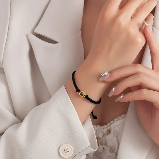 Handwoven cord bracelet with an 18K gold-plated hidden photo centrepiece