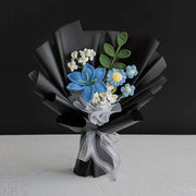 青のかぎ針編みのユリの花束と黒のラッピング