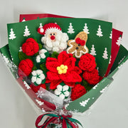 Vista ravvicinata del bouquet natalizio con stella di Natale rossa dal centro giallo, rose rosse e fiori di cotone bianchi nella carta verde con alberi
