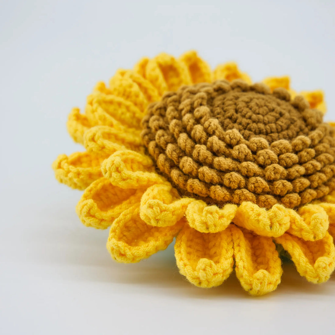 Très gros plan du tournesol amélioré au crochet avec pétales jaunes et cœur brun texturé