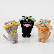 Crochet cat doll with a fish, standing on a wire-shaped tail