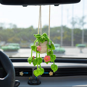 Light green crochet hanging pot with pink and white flowers and hollowed leaves