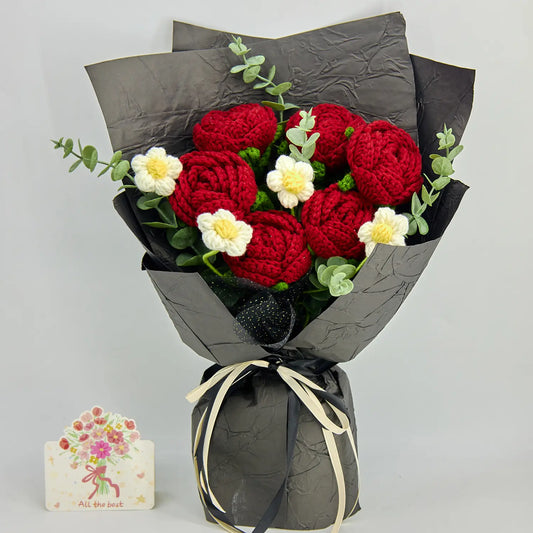 Vue complète d’un bouquet de six roses au crochet rouge profond avec fleurs blanches, feuillage façon eucalyptus, emballage noir et ruban noir et crème