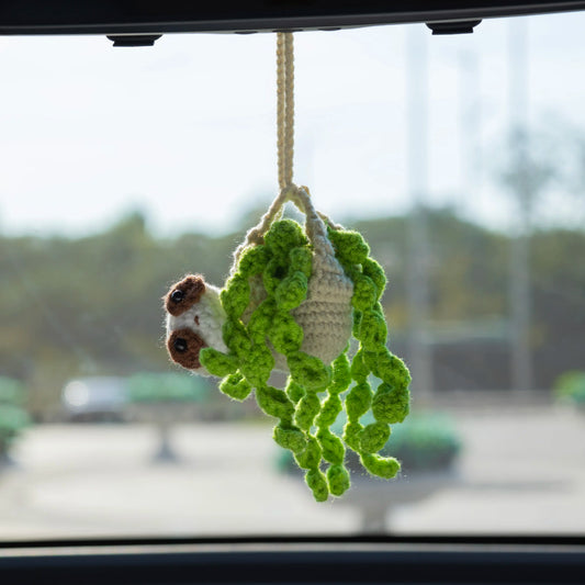 Crochet car hanging combining a sloth bear doll with a potted plant